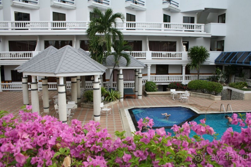 Территория отеля с бассейном и кругом цветы