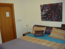 большая спальня с ТВ, дверь в малый санузел