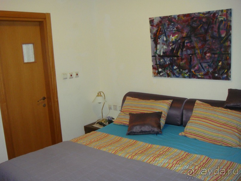 большая спальня с ТВ, дверь в малый санузел