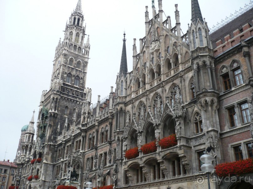 Идем дальше. Недалеко от пивной находится главная площадь Мюнхена – Мариенплатц. На ней располагается очень красивое здание так называемой Новой ратуши. Новая, потому что рядом стоит старая. Хотя строительство новой закончено в 1909г. 

Здание построено в неоготическом стиле.
