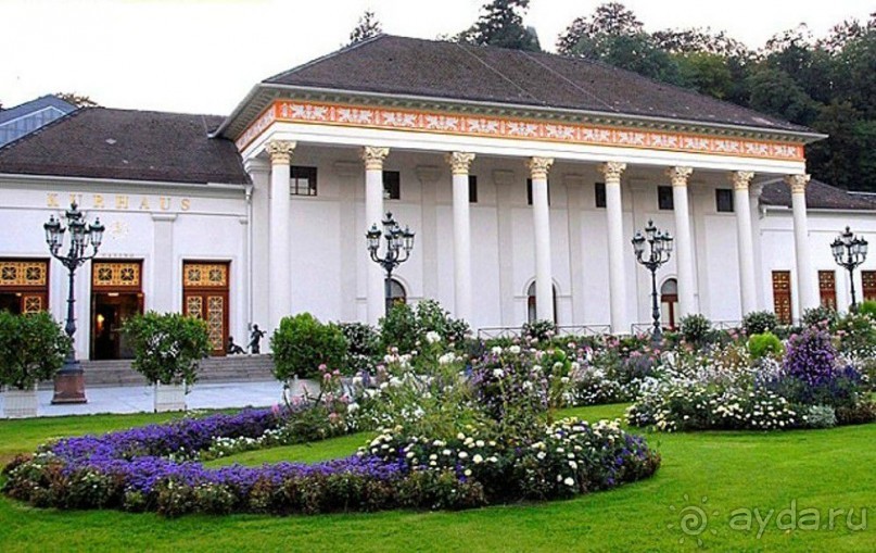 Интересно, что здание Курхауса (курортного дома), а котором располагается Баденское казино, внешне совсем не выглядит роскошным. Фото из Интернета.
Там, где открыта дверь, прямо над ней, стоит неприметная надпись «Казино». Это и есть вход в него. Фонари перед Курхаусом газовые
 
