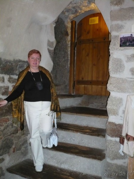 Там мы походили по замку, спустились в его подвалы. 
Я стою на лестнице, ведущей в подвал. Невероятно, но деревянным доскам на поверхности каменных ступеней 800 лет!!! Говорят, что дерево пропитывалось бычьей кровью, которая выступала в качестве консерванта. Поэтому дерево служит уже столько много лет.
