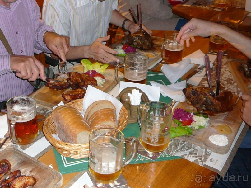 Пиво мы там пили всякое, начали с нефильтрованного. Потому что нам сказали, что такое пиво нужно обязательно пить женщинам, оно очень полезное. Но на вкус мне не очень то понравилось.  После нефильтрованного я заказала себе ещё темного пива. А потом принесли горячее.
Все, конечно же, заказали рульку. Вообще, в этом ресторане готовят очень вкусно по традиционным чешским рецептам, в том числе и из дичи. Я там заказывала что-то из оленя или косули, потому что рульку уже ела неоднократно. Очень вкусно. Своё блюдо я не сфоткала. А вот так вот выглядит их рулька.
Как видите, подают на досточках. В рульку воткнуты нож и вилка. Рядом немного гарнира и в двух углублениях хрен и горчица. Горчица вкуснейшая, совсем не острая. Стоит всё это удовольствие что-то 260-280 крон.
