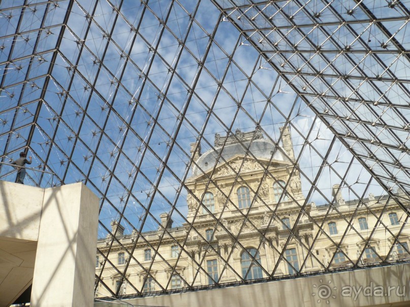 По поводу построенной пирамиды было много шумихи. Кто-то совсем её не принимал, считал, что она абсолютно не вписывается в архитектурный ансамбль всего Лувра. На мой взгляд, она не безобразит окружающий вид, а оживляет его. Благодаря этой пирамиде, музей обрел свой исключительный неповторимый образ.
А вот вид на пирамиду изнутри.
