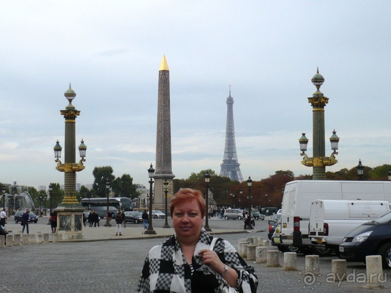 На Площади Согласия мы впервые увидели Эйфелеву башню. Мы радовались как дети и скорее кинулись фотографироваться на её фоне.
Первоначально площадь была посвящена Людовику XV, конная статуя которого возвышалась в её центре. Но памятник был уничтожен во время Французской революции. На его месте водрузили гильотину, под нож которой попали многие политические деятели того времени, в том числе Людовик XVI, королева Мария Антуанетта, Робеспьер. Сейчас в центе площади стоит египетский обелиск из Луксора, подаренный Луи Филиппу египетским пашой, он украшен иероглифами, знаменующими славные деяния фараона Рамсеса II. Этот обелиск виден за мной. 
