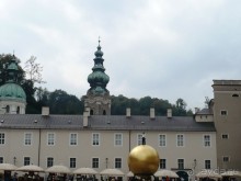 Этот золотой шар я сначала приняла за какой-то цирковой трюк. Думала, что на улице показывается какое-то цирковое представление. Мне казалось, что на шаре стоит живой чернокожий человек. Ничего подобного. Это так называемая современная инсталляция. Поставлена якобы для украшения города. Не знаю, что она там украшает. Среди исторических памятников эта штука вызывает недоумение. Что она собой символизирует, тоже непонятно. Жители Зальцбурга иронично обозвали её между собой «Барак Обама на шаре». Что-то подобное я даже видела возле Лувра в Париже. Так же натыканы современные штуки возле старых скульптур.  Смотрятся крайне нелепо. 

