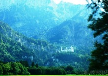 Замок Ноншванштайн виден издалека, еще на самых дальних подъездах к нему. Он кажется маленьким домиком на фоне величественных Альп.Замок находится на горе, на нее можно взобраться пешком или доехать на специальном автобусе за небольшую плату. Пешком идти довольно круто и высоко, поэтому мы предпочли проехаться на автобусе. 

