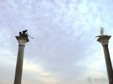 …и вышли на пьяццетту (помните, что это часть площади Сан-Марко, которая выходит к воде?). 

Первое, что мы увидели издалека и сразу – это две капители (столба). Они были привезены в Венецию с восточного побережья Средиземного моря в 1170 г., одну из колонн венчает статуя льва Св. Марка, другую - Св. Теодор, один из покровителей Венеции. 

Надо сказать, что местные жители предпочитают не проходить между этими колоннами. Это считается плохой приметой, связанной с тем, что когда то здесь происходили публичные казни.