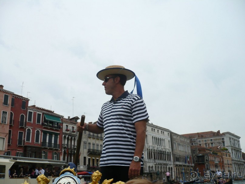 Говорят, что гондольер – это не просто профессия, это образ жизни. Гондольерами просто так не становятся. В эту профессию строгий отбор и конкурс. Ведь количество гондольеров ограничено. Их всего по всей Венеции 450. Не больше и не меньше. Искусству гондольеров учат 4 года (почти что высшая школа).

 Гондольеры постигают не только мастерство управления гондолой, но и учатся петь. Гондольеры – особая каста в Венеции. Они – хозяева каналов. От них город узнаёт новости. Катая туристов, они успевают общаться между собой, перекрикиваясь на своём венецианском диалекте. При этом их разговоры слышат жители домов, мимо которых они проплывают.

Классический образ гондольера – высокий,  подтянутый, мужественный и романтичный. Подтверждаю, они именно такие.  У них есть своя униформа. Наш был в полосатой рубашке и светлой шляпе с лентами. Вот он, наш красавчик.
