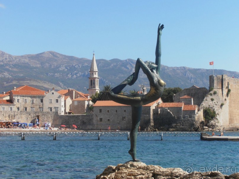 Такая девочка по дороге на пляж в городе Будва.на фоне старой крепости.