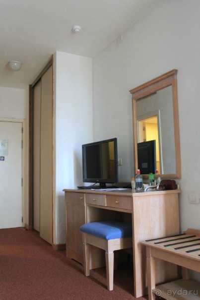 Номер. Слева от стола в тумбочке холодильник.