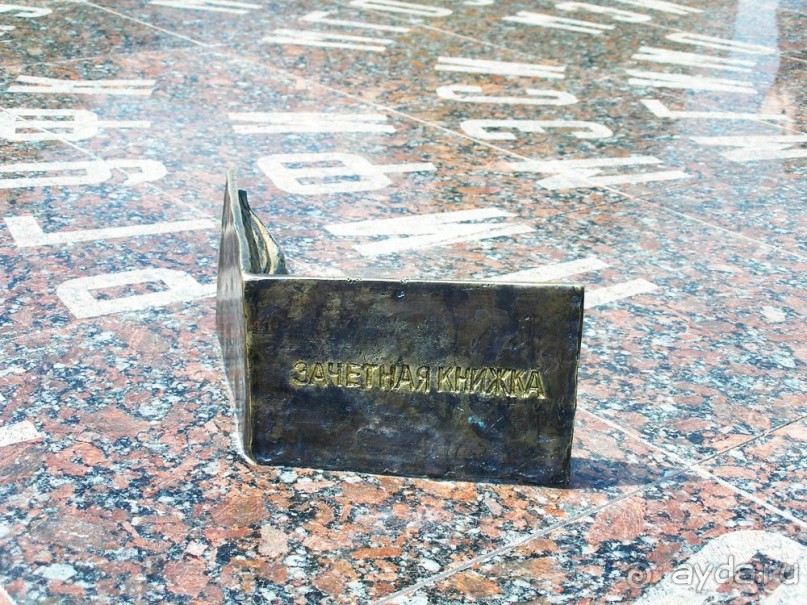 Необходимо  приложить свою зачетку к ее бронзовому прототипу.