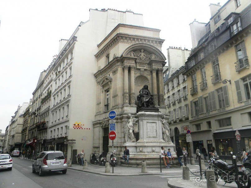 Фонтан Мольера – скорее не полноценный фонтан, а монументальный памятник великому драматургу. Стоит он на углу улиц Мольера и Ришелье, неподалёку от театра Комеди Франсез, в котором комедиограф играл и для которого писал,  напротив дома, где он жил и умер