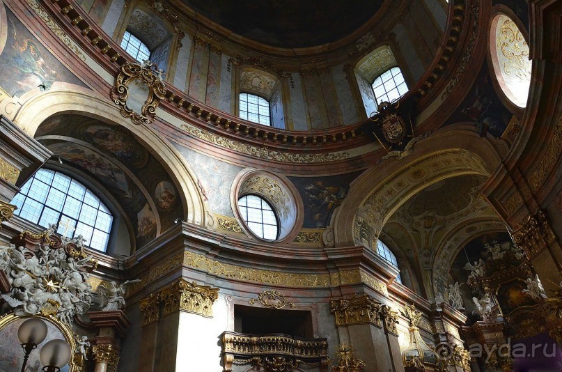 Так как эта барочная церковь посвящена Пресвятой Троице, в ней везде можно видеть изображения и символы главного таинства католической веры.  Вверху великолепный купол, богато украшенные окна, фигуры четырех евангелистов и четырех латинских отцов церкви на надсводной части арки, императорский герб с девизом Леопольда I над триумфальной аркой.