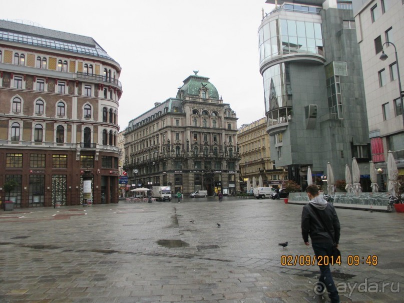 Когда-то, в XIX веке, на этом месте  стоял купеческий дом (в нем торговали коврами), но во время Второй мировой войны он был разрушен. Теперь же здесь красуется новый торговый комплекс с дорогущими магазинами и пафосным кафе-рестораном на крыше
