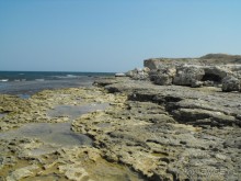 каменный пляж,берите ссбой потолще покрывало,удобно будет лежать. 
