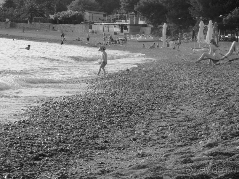 пляж противоположного от острова конца, если спуститься вниз вертикально от отеля, там камни крупнее и босиком входить в воду трудно